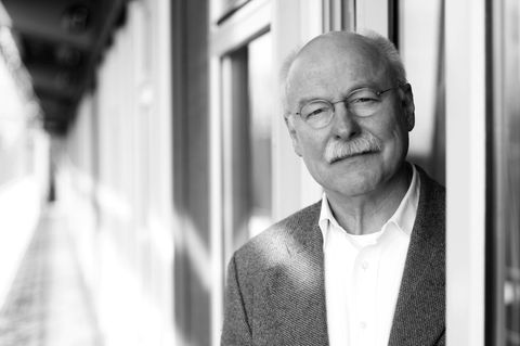 Michael Seufert blickt aus einem Türrahmen auf einen Flur.