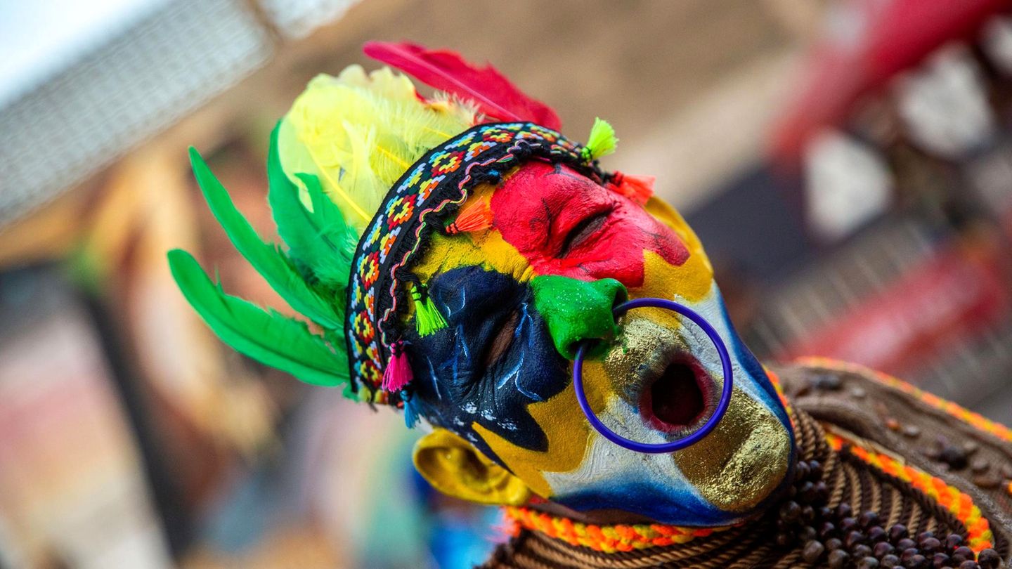 Ein Mann mit nach indigener Tradition bemaltem Gesicht nimmt am Karnevalsumzug in Kolumbiens Stadt Barranquilla teil