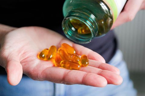 Vitamine: Zehn Fischölkapseln auf einer Hand