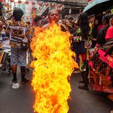 Ein Feuerspucker spuckt Flammen für die Zuschauer aus