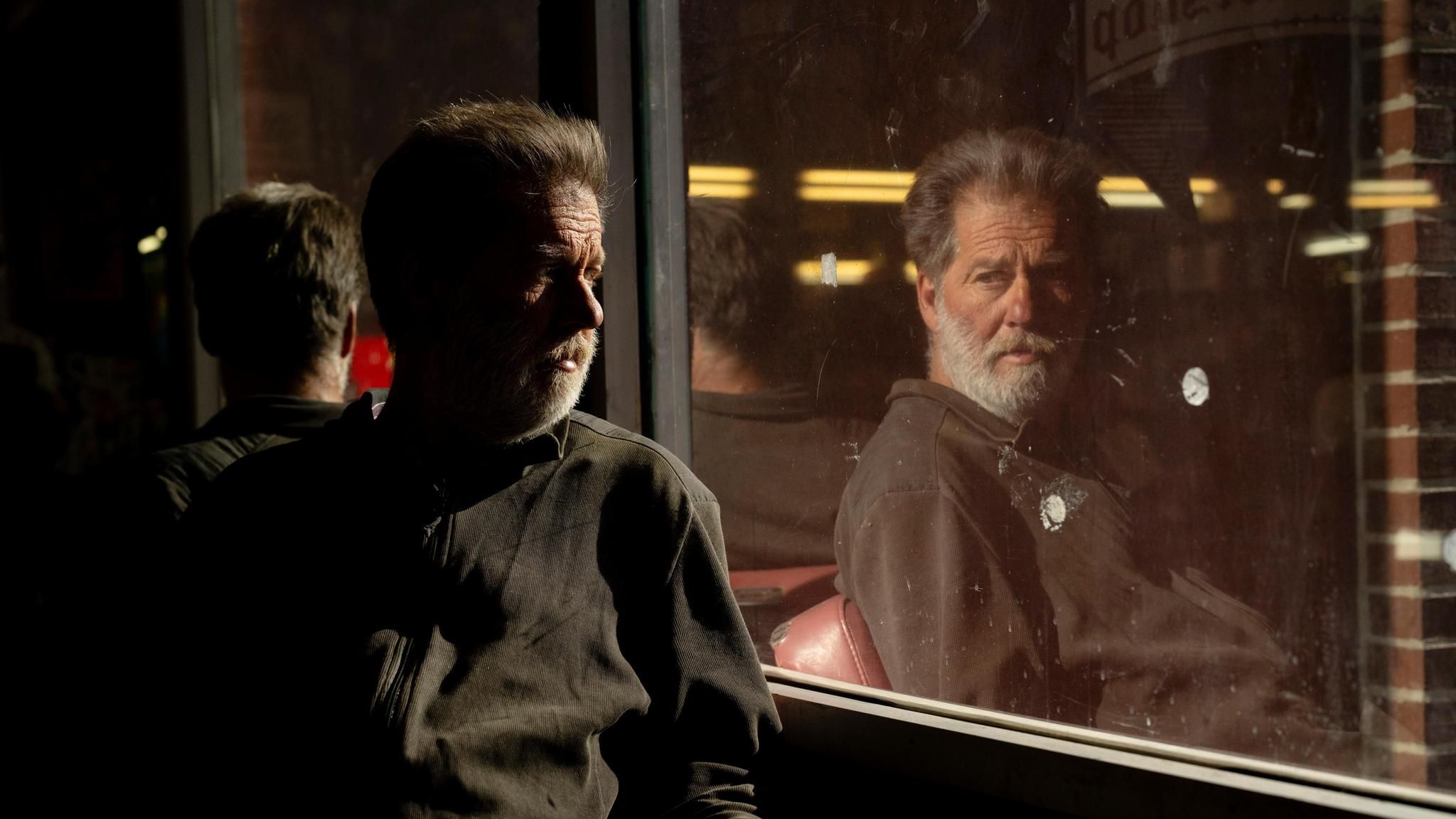 William Woods spiegelt sich im Fenster eines Friseursalons