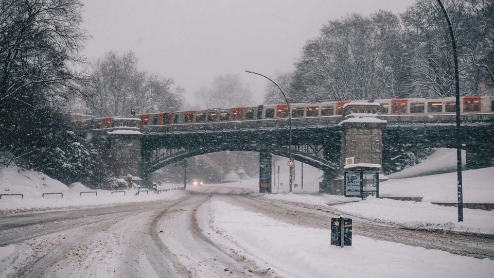 Eine U-Bahn auf einer Brücke in Hamburg, während es stark schneit