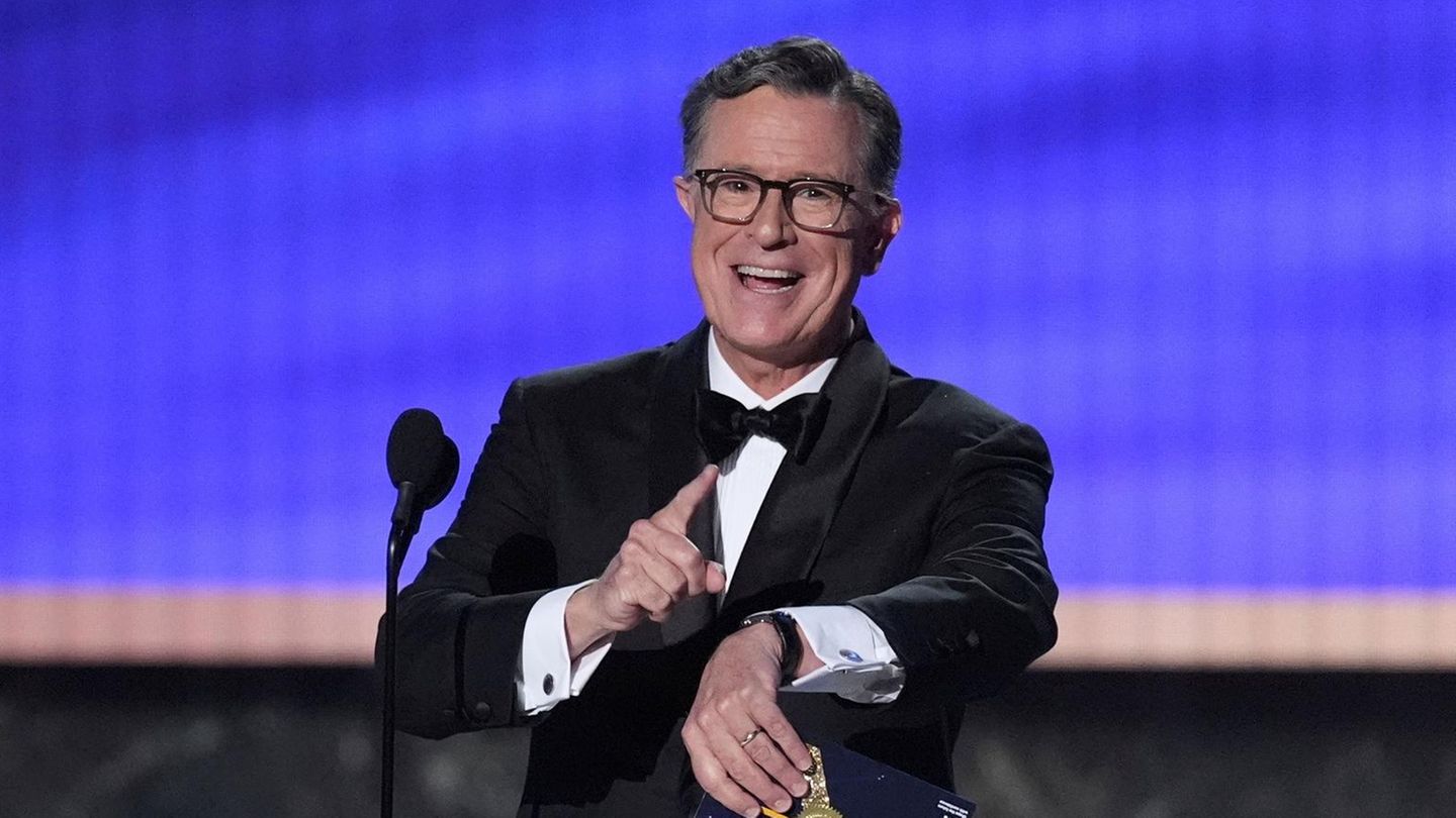 Talk-Show-Host Stephen Colbert  steht grinsend auf einer Bühne