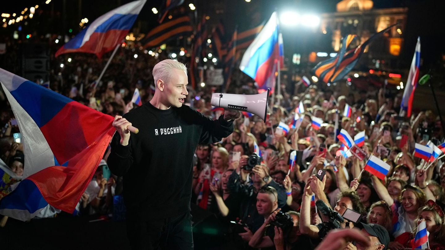 Vor dem Ukrainekrieg war Jaroslaw Dronow nur einer von vielen mehr oder weniger erfolgreichen Popsängern in Russland. Ein wirklich breites Publikum fanden seine Balladen nicht. Fast zeitgleich mit dem russischen Angriffskrieg auf die Ukraine 2022 erlebte seine Karriere einen Schub. Er sattelte um. Seine Songs sind heute eine Mischung aus Selbstüberhöhung und Nationalismus – immer nah an der metaphorischen Kriegsverherrlichung. In der Öffentlichkeit nennt er sich „Shaman“, auf seiner Bühne und im Publikum wehen russische Flaggen. Dronow ist der Prototyp eines Popstars auf Kremllinie. Und die Massen singen begeistert mit. Seine Lieder tragen Titel wie „Mein Kampf“ oder „Erheben wir uns“. Shaman liefert den Soundtrack zu Putins Krieg im Nachbarland.