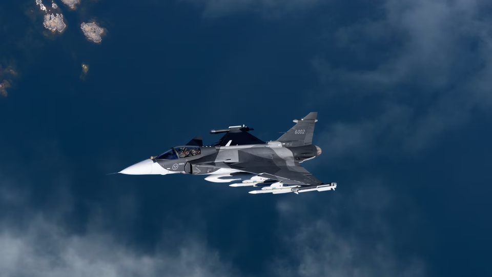 Eine mit Raketen bewaffnete Saab Grippen über dem Meer