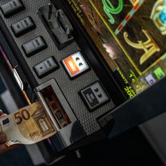 Geld wird in einem Spielautomaten gesteckt. Mehrere solcher Maschinen beschlagnahmten Beamte der Polizei in Görlitz. (Symbolbild