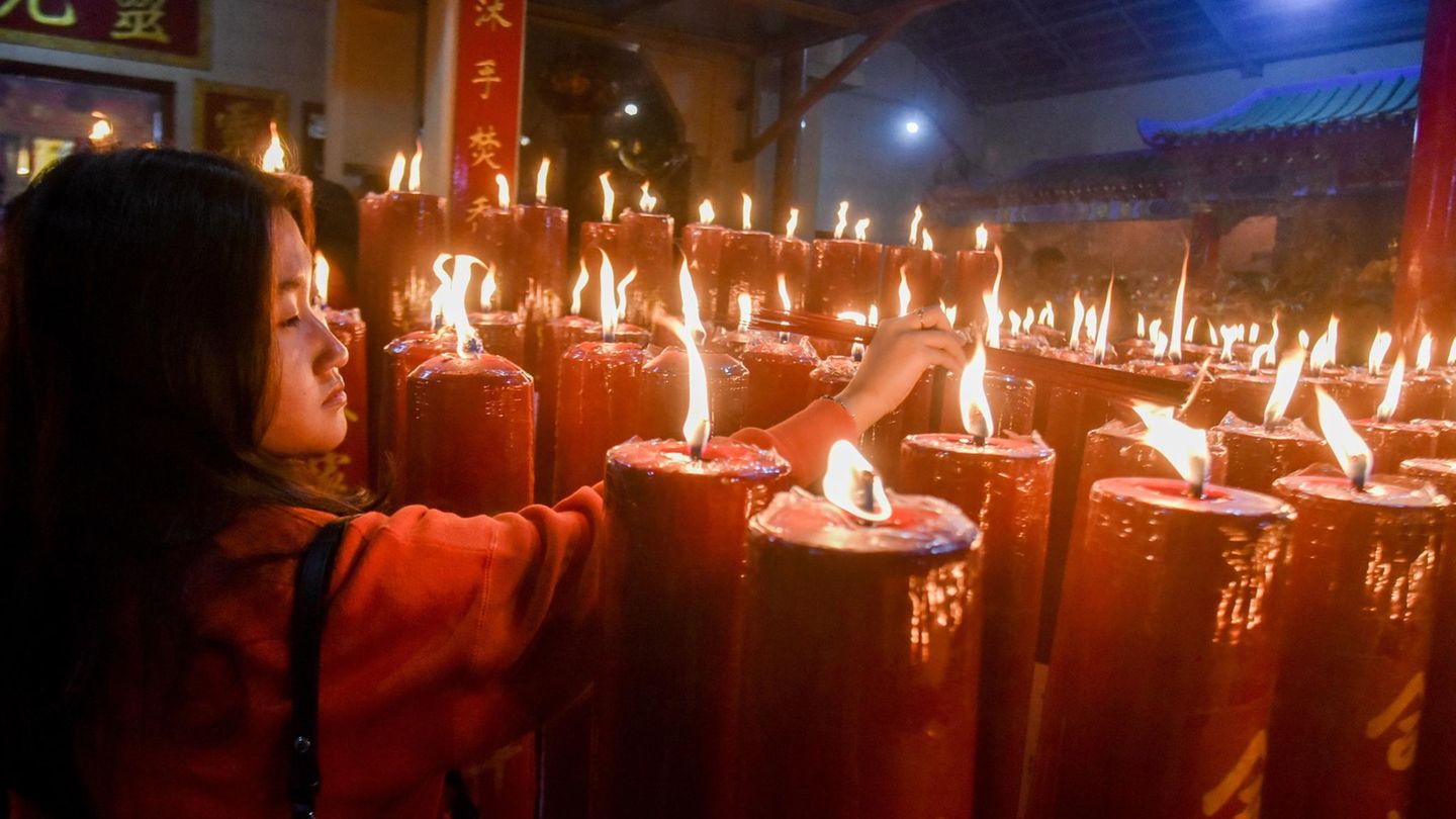 Diese Frau zündet rote Kerzen in einem indonesischen Tempel in West-Java an. Bei den Feierlichkeiten spielt Rot eine große Rolle. Traditionell soll die Farbe Glück bringen, während Schwarz und Weiß mit Trauer assoziiert werden. Auch deshalb wird an den Feiertagen von vielen rote Kleidung getragen. 