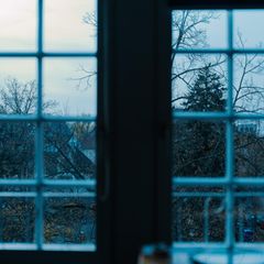 Symbolbild Depressionen: Blick aus dem Fenster auf graue Straßen und Himmel