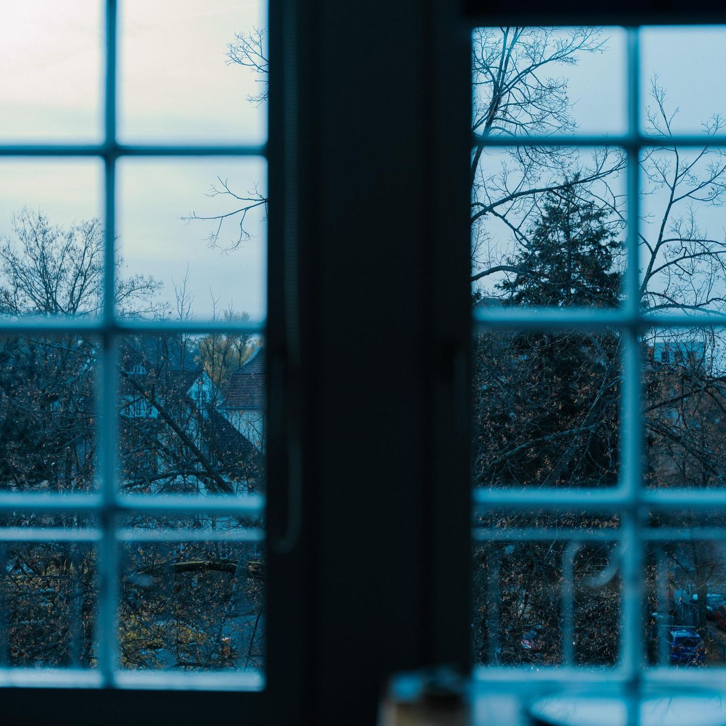 Symbolbild Depressionen: Blick aus dem Fenster auf graue Straßen und Himmel