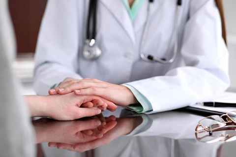 Vertrauen: eine Ärztin hält die Hand eines Patienten