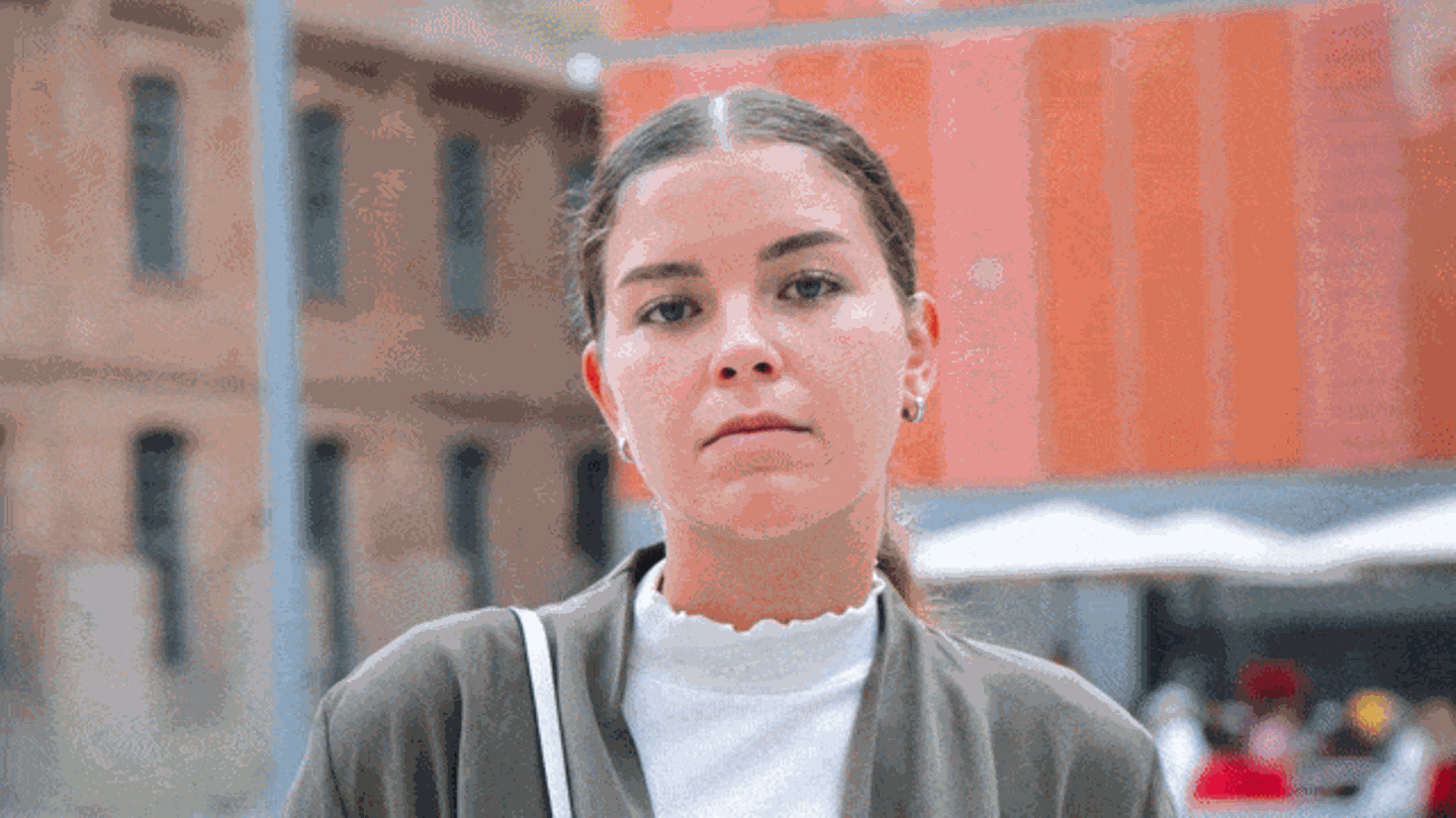 Eine junge Frau schaut selbstbewusst in die Kamera