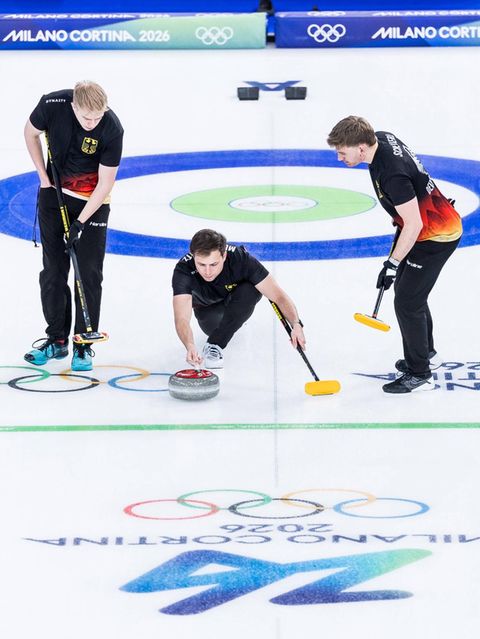 Olympia drei Curlingspieler bei der Steinabgabe