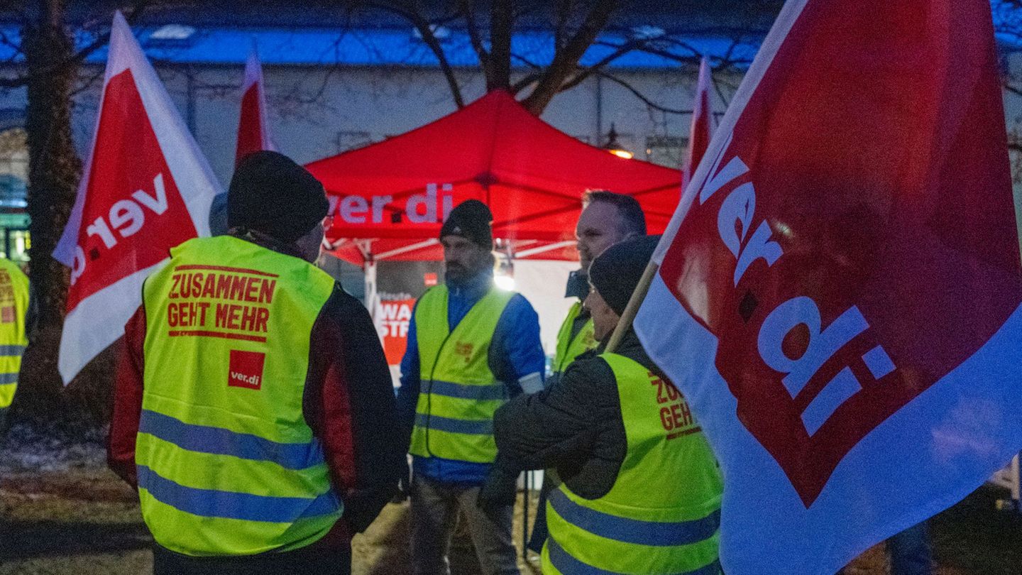 Streikende halten Fahnen der Gewerkschaft Verdi und sind mit Warnwesten gekleidet. Foto: Stefan Puchner/dpa