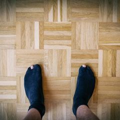 Deal-News-Socken: Ein Mann trägt schwarze Socken mit Löchern