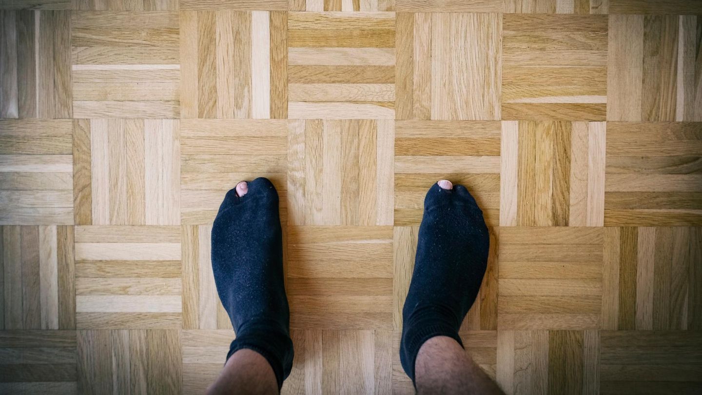 Deal-News-Socken: Ein Mann trägt schwarze Socken mit Löchern