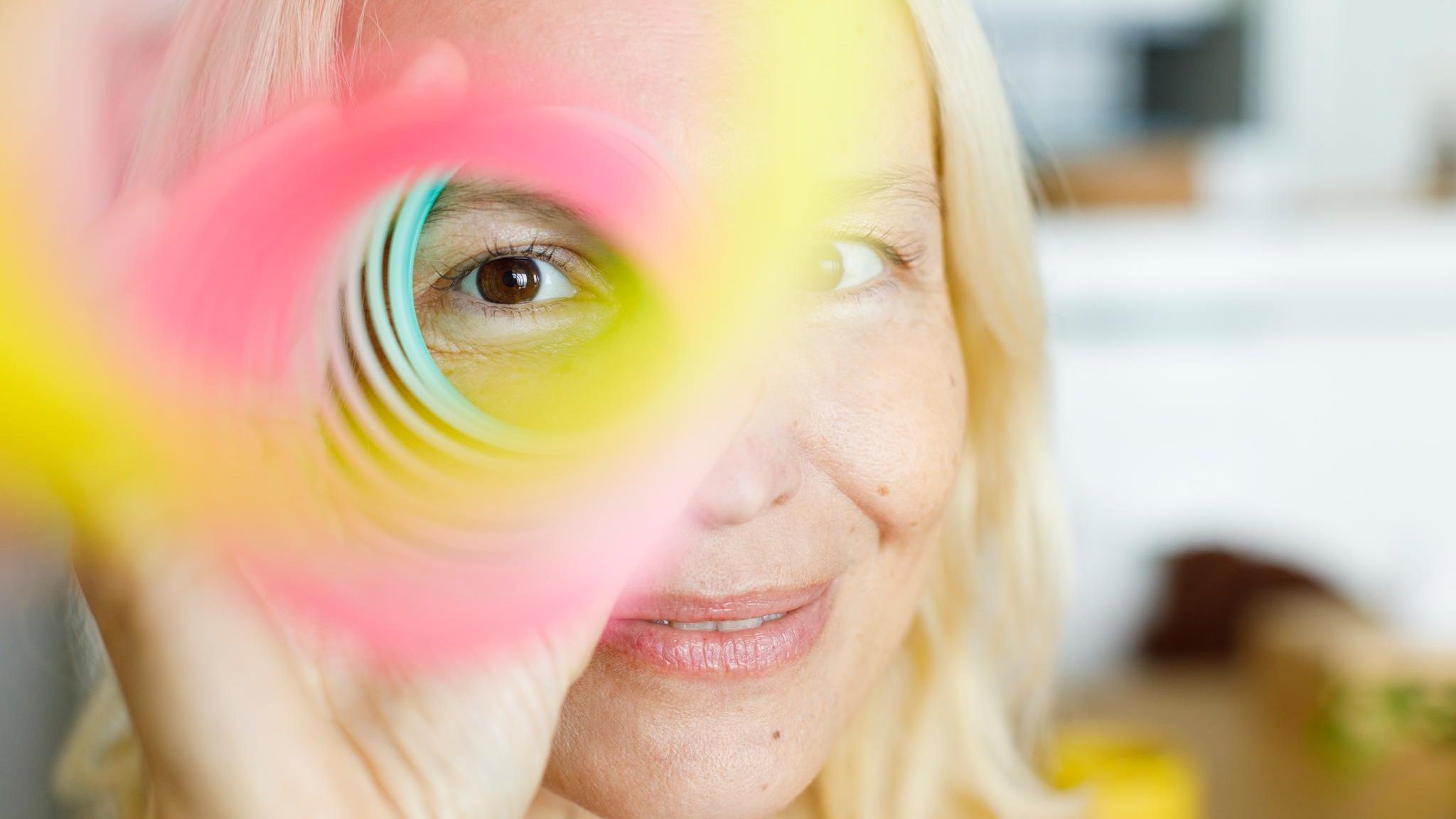 Frau schaut durch buntes Guckloch