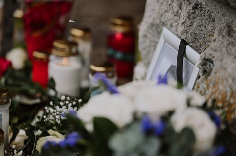 Vor dem Rathaus haben viele Menschen Kerzen und Blumen abgelegt. Foto: Marius Bulling/dpa