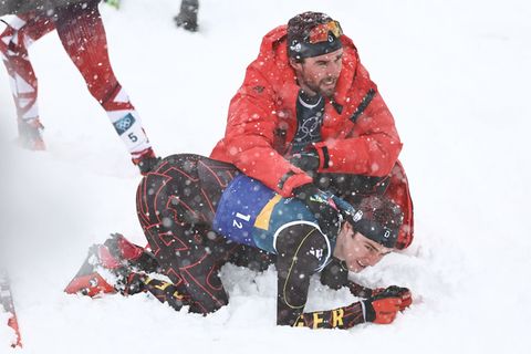 Vinzenz Geiger liegt im Schnee und wird von Teamkollege Johannes Rydzek getröstet. Foto: Daniel Karmann/dpa