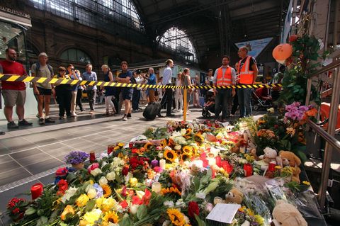 Gedenkstätte am Gleis im Frankfurter Hauptbahnhof. Der Boden ist mit Blumen bedeckt.