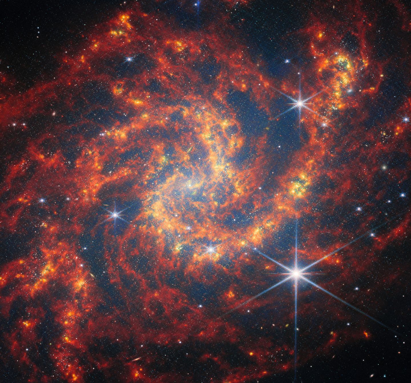 Leuchtend rote und orangene Gas- und Staubwolken in der Spiralgalaxie NGC 2283