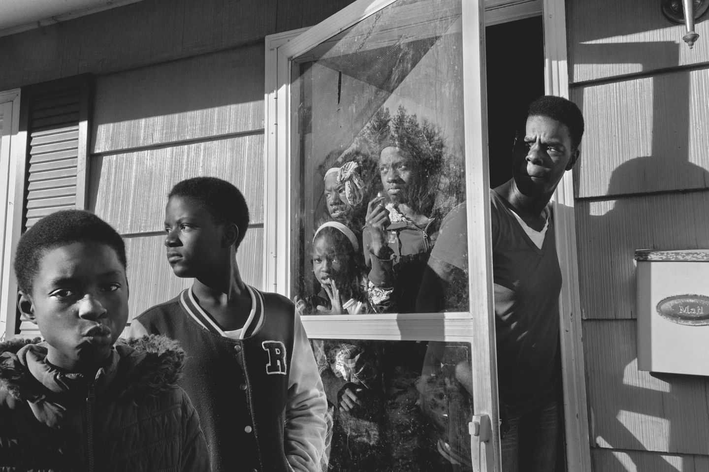 Eine Familie steht in der Tür ihres Hauses und schaut gebannt nach draußen