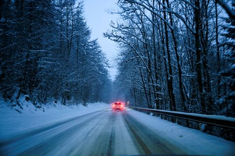 Auto auf verschneiter Landstraße