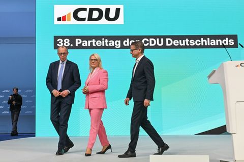 Merz (links) vor Parteitagstribühne in Stuttgart