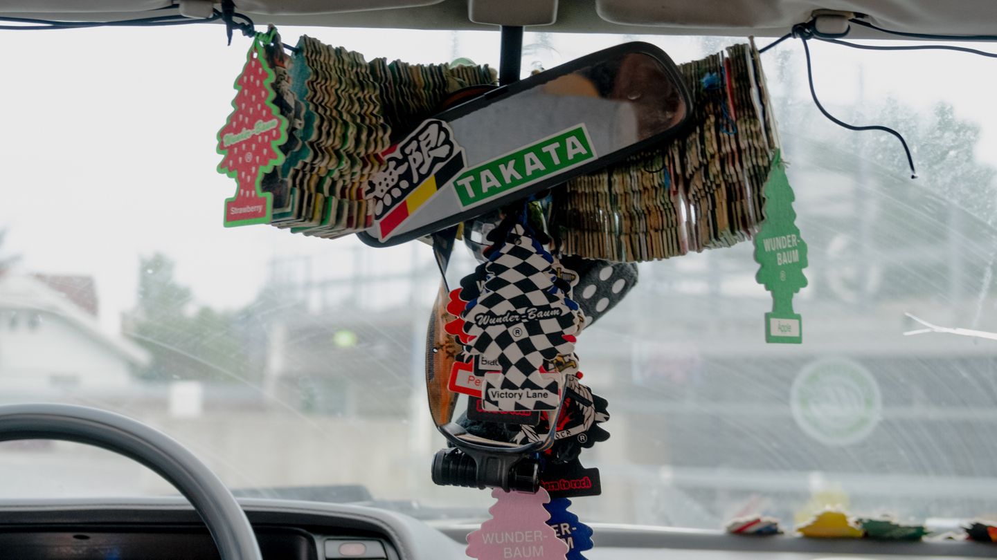 Nahaufnahme einer sehr langen Reihe von Duftbäumen in einem Auto