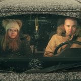 Ein Paar sitzt in einem halb zugeschneitem Auto