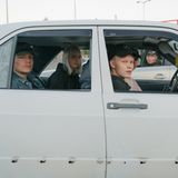 4 Jugentliche sitzen in einem alten Auto und schauen in die Kamera