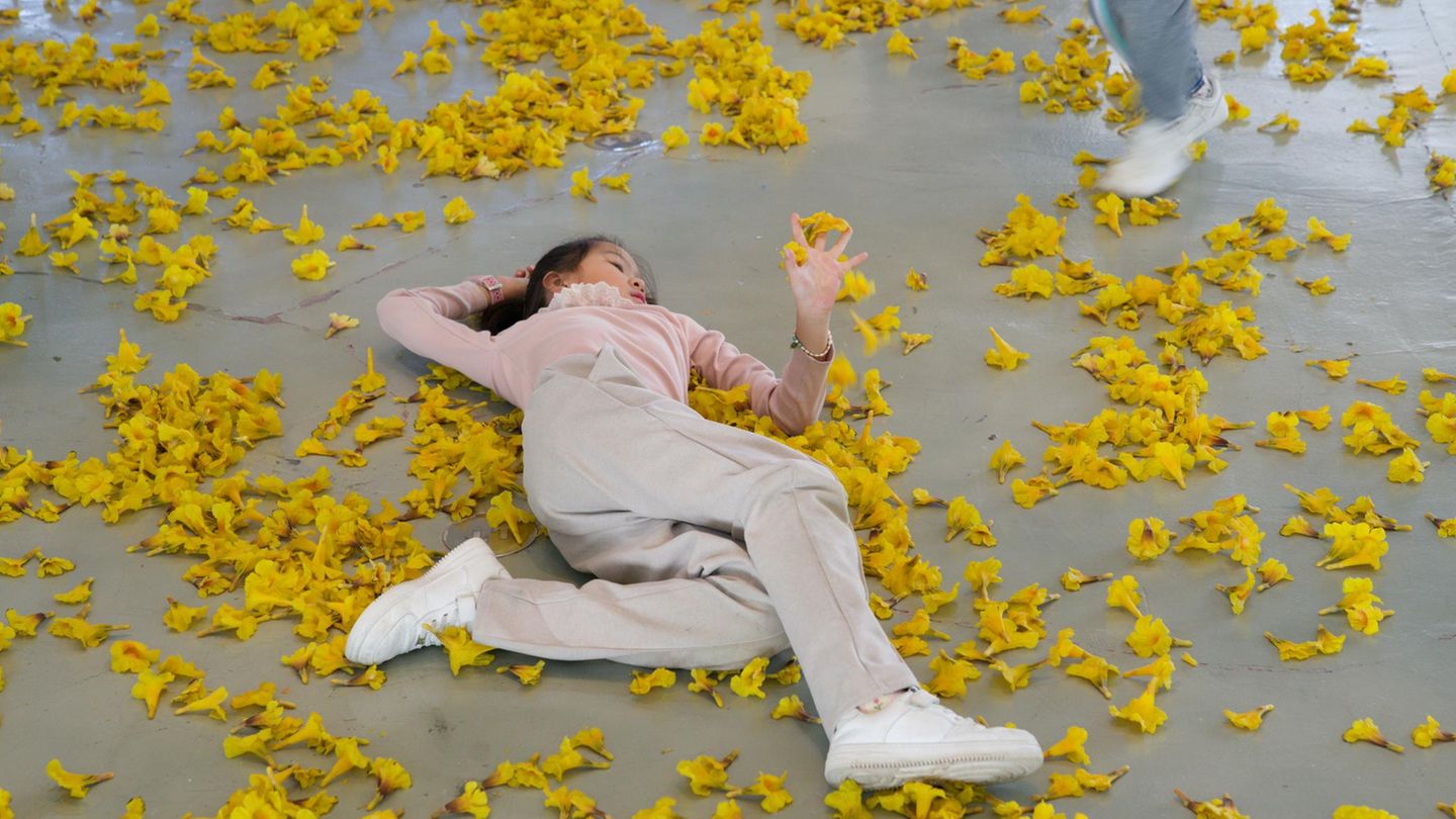 Ein Kind bei der Shanghai Biennale in gelben Blättern