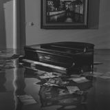 Ein Flügel steht in einem überfluteten Wohnzimmer, drum herum schwimmen Papiere und Hefte