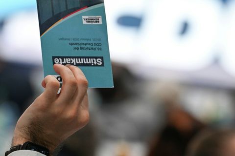 Delegierter hebt Stimmkarte bei CDU-Parteitag
