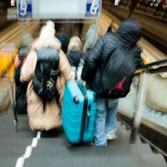 Reisende tragen auf dem Berliner Hauptbahnhof neben den gesperrten Rolltreppen große Koffer die Treppen hinab zum Bahnsteig. Fot