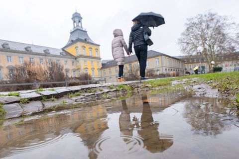 Pfützen und Regenschirm: Auch in den kommenden Tagen müssen sich die Menschen in NRW auf Regen einstellen. Foto: Benjamin Westho