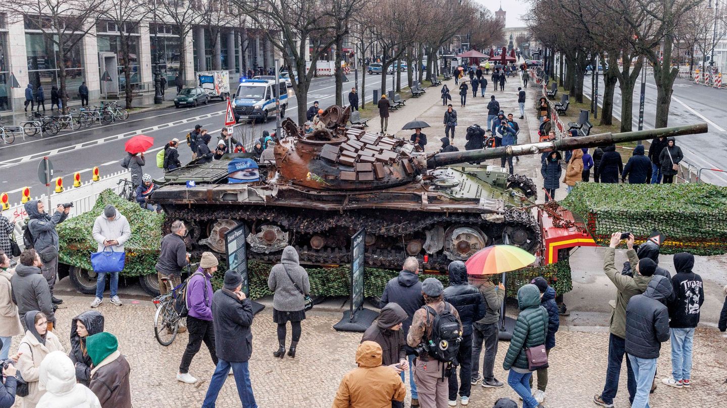 Passanten stehen 2023 vor einem in der Ukraine zerstörten russischen Panzer. (Archivbild) Foto: Carsten Koall/dpa