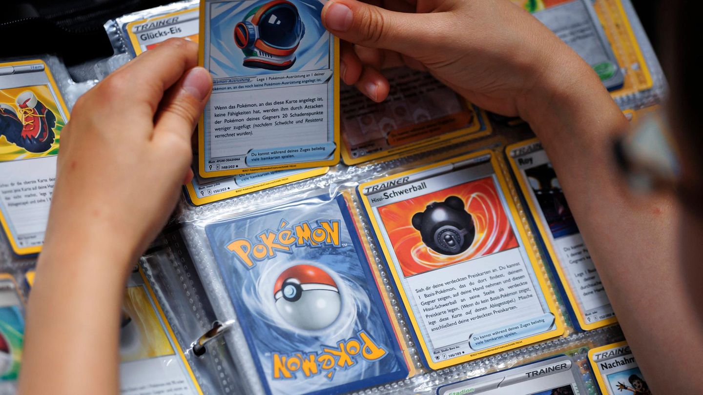 Eine Person hält Pokémon-Karten in der Hand