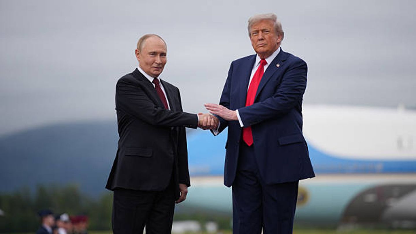 Donald Trump (rechts), Präsident der Vereinigten Staaten, begrüßt seinen russischen Amtskollegen Wladimir Putin am 15. August 2025 bei ihrem Treffen auf dem Flughafen der "Joint Base" Elmendorf-Richardson in Alaska zu Friedensgesprächen. Inzwischen hängt das Bild im Weißen Haus.