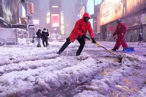 Ein Arbeiter schaufelt Schnee auf dem Times Square in New York. Ein heftiger Schneesturm zieht über den Nordosten der USA hinweg