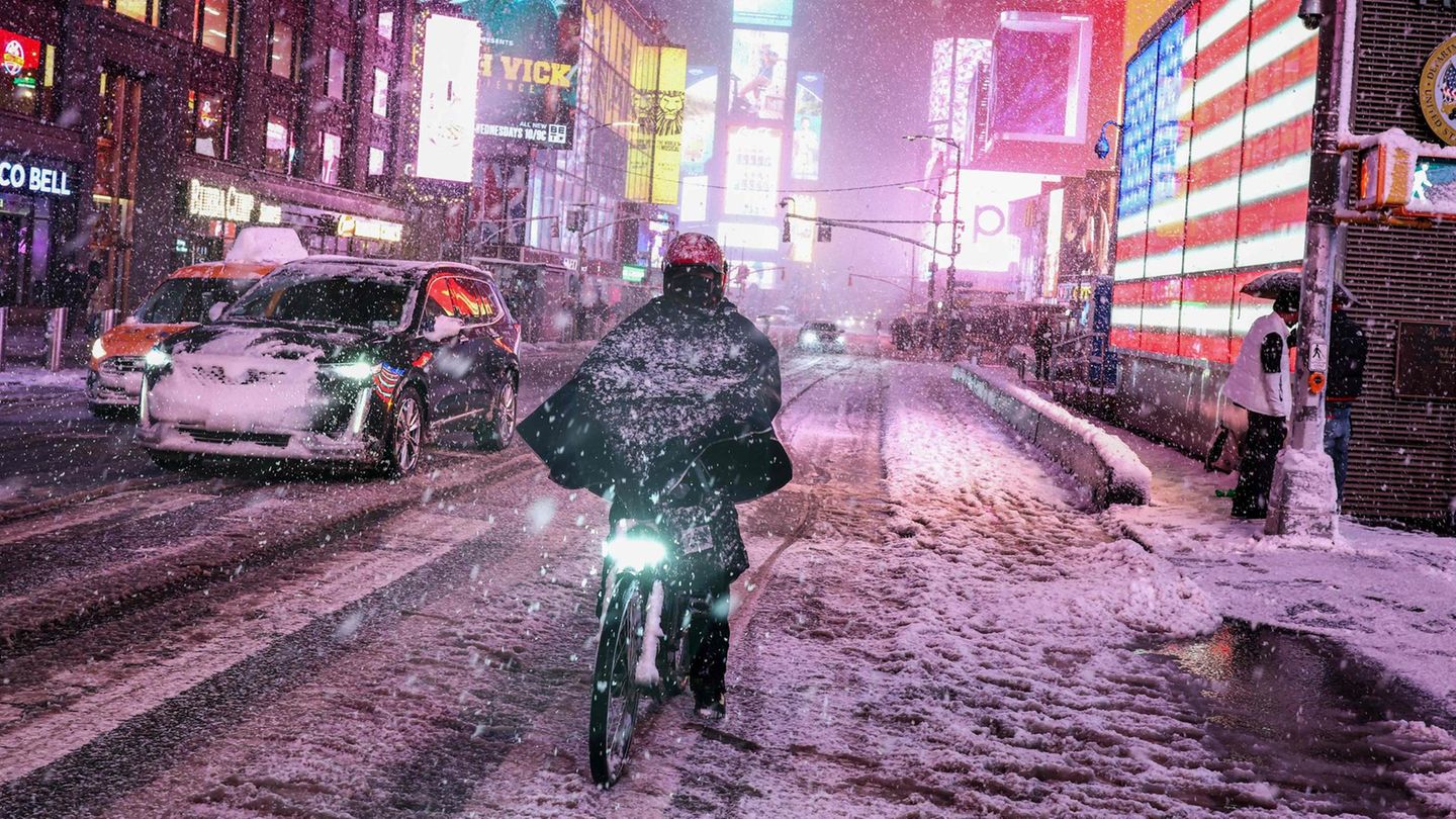 New York City, USA. Wo sonst gelbe Taxis stockend vorankommen, kämpft sich ein Radfahrer entschlossen durch den Schneematsch am Times Square, flankiert von leuchtenden Werbebannern. Ein heftiger Wintersturm mit Schnee und starken Windböen hat den Nordosten der USA zeitweise weitgehend lahmgelegt. In den Bundesstaaten New York, New Jersey, Pennsylvania, Delaware und Connecticut fielen mehr als 30 Zentimeter Schnee. Die Behörden in New York verhängten ein Fahrverbot und sperrten zeitweise Straßen, Autobahnen und Brücken – ausgenommen für Rettungsfahrzeuge. Doch im Big Apple scheint das nicht jeder bemerkt zu haben.