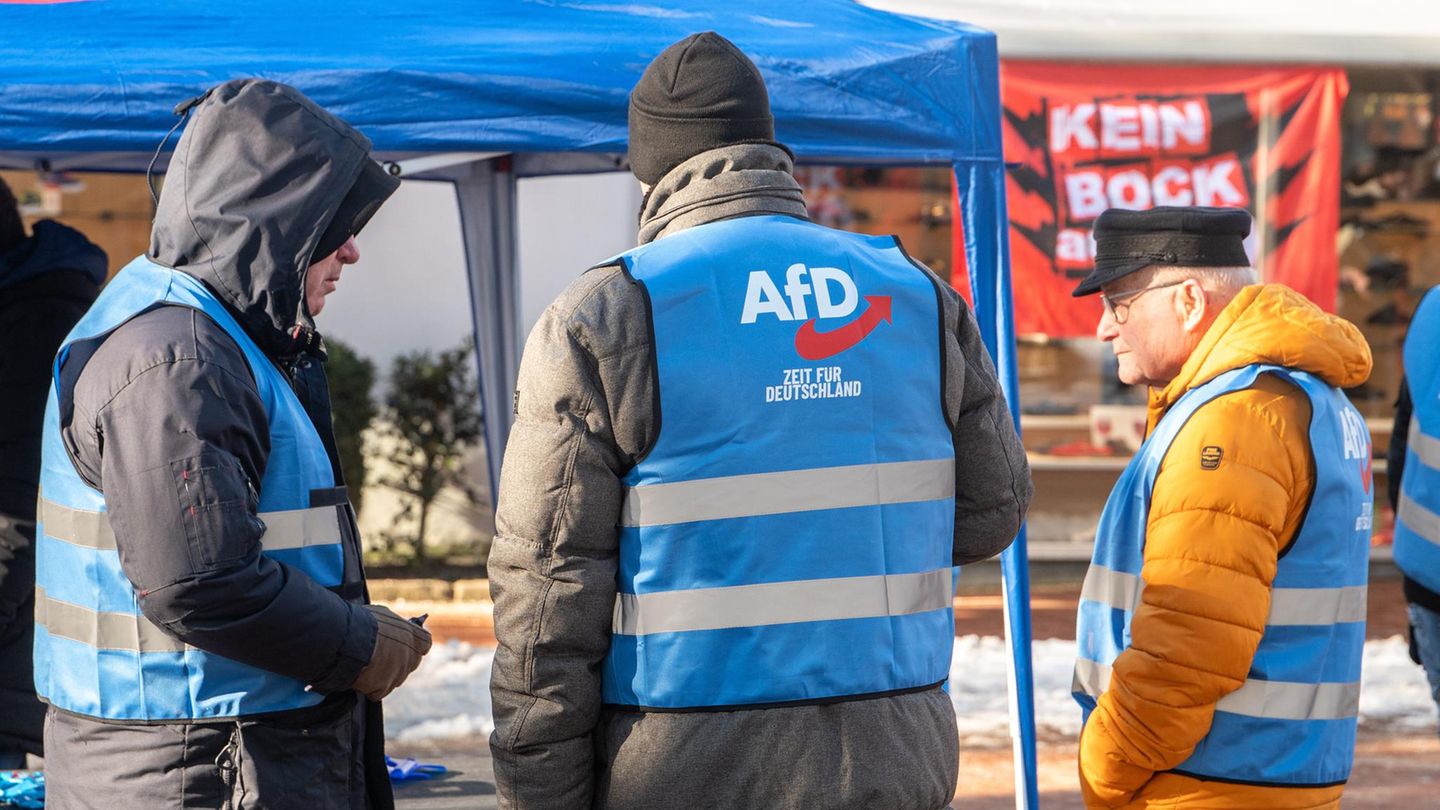 Ein AfD-Stand mit drei Männern davor