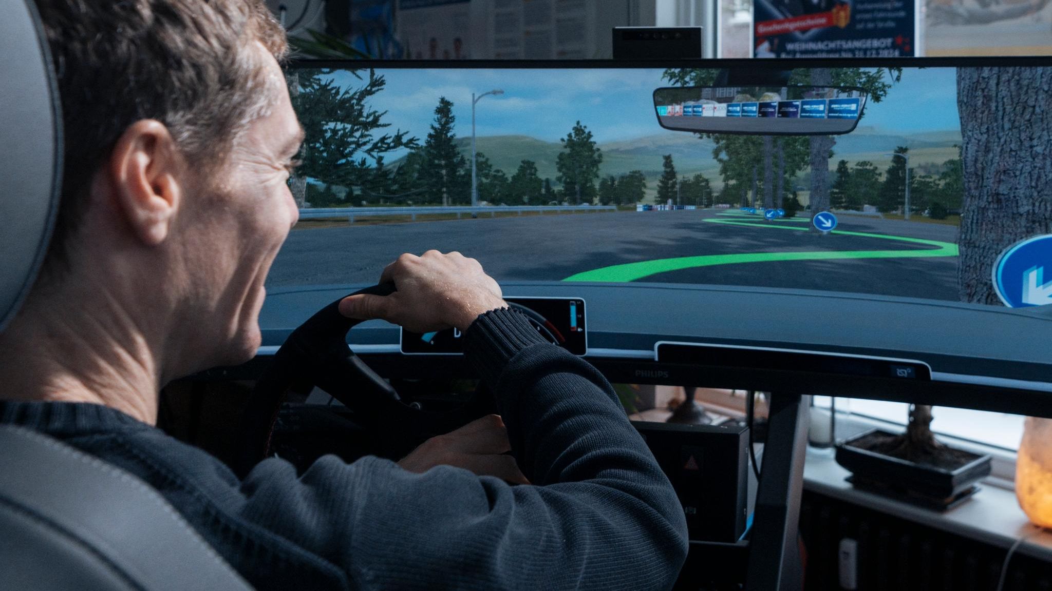 Ein Fahrschüler lenkt den Fahrsimulator