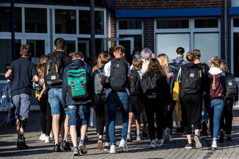 Gruppe von Jugendlichen vor einer Schule im Jahr 2020