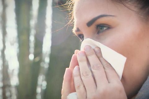 Frau schnieft in Taschentuch