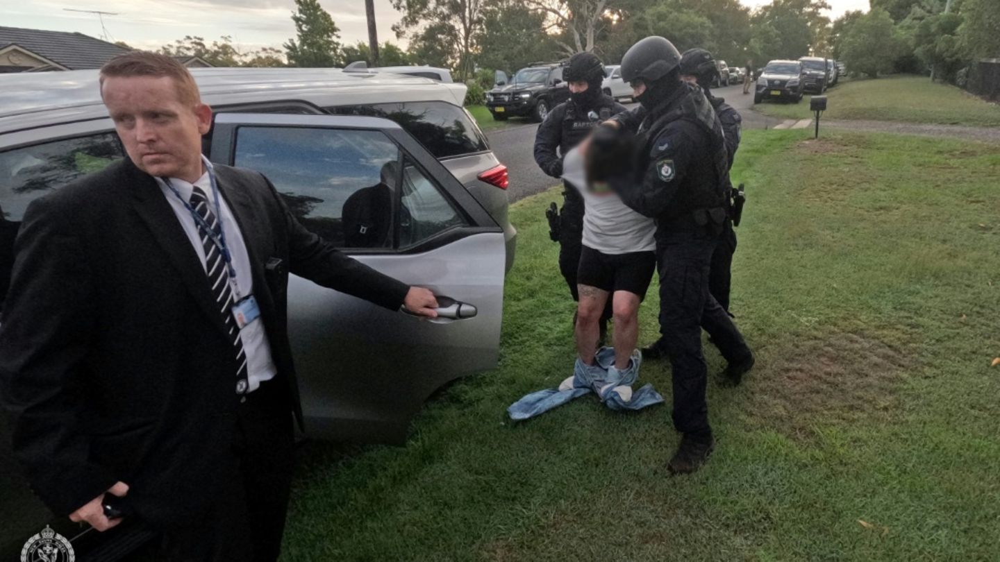 Polizisten führen einen der Verdächtigen ab