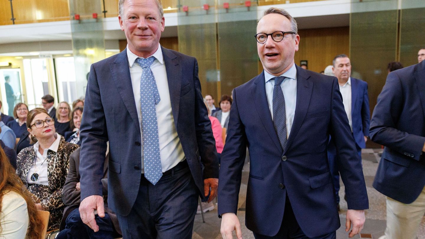 Carsten Günther (l) geht bei seiner Amtseinführung neben NRW-Justizminister Benjamin Limbach in die Halle des OVG. Foto: Friso G