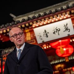 Kanzler Merz vor einem Tempel mit chinesischen Schriftzeichen.