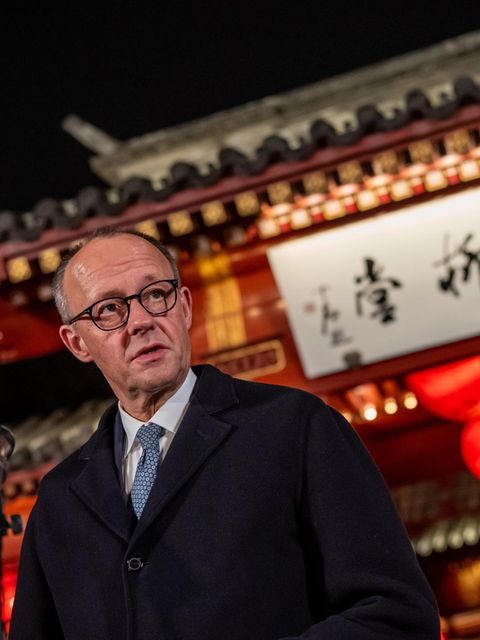 Kanzler Merz vor einem Tempel mit chinesischen Schriftzeichen.