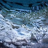 Wohlenberg, Deutschland. Auch wenn in Deutschland das Tauwetter eingesetzt hat, treiben in der Wismarer Bucht noch immer viele Eisschollen an der Küste. Es ist der Übergang vom eisigen Winter zum milden Frühling. Von oben betrachtet sieht dieses winterliche Schauspiel aus wie ein abstraktes Gemälde oder ein großes Puzzle.