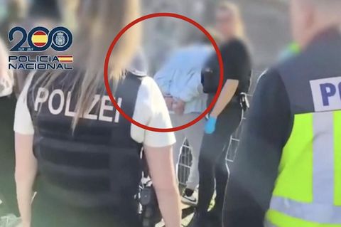 Deutsche und spanische Polizisten nehmen eine Person fest.